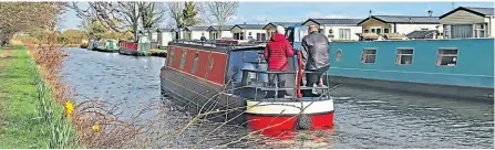  ?? PHOTO: COLIN WAREING ?? A narrowboat on the move along the Leeds & Liverpool Canal between Halsall and Burscough, West Lancashire. On the offside of the canal are the moorings alongside the Shaw Hall caravan park at Scarisbric­k.