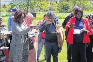  ?? SAM MCNEISH/THE TELEGRAM ?? A group of new Canadians celebrate the blessing of the water, flowers and garden at the Mercy Centre of Ecology and Justice on Mount Scio Road in St. John’s.