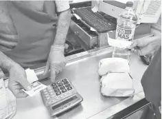  ?? — AFP photo ?? A customer pays in a small market in Buenos Aires. President Mauricio Macri to announce anti-inflationa­ry measures to reactivate the economy in recession-hit Argentina.