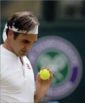  ?? TIM IRELAND— ASSOCIATED PRESS ?? Roger Federer prepares to serve to France’s Adrian Mannarino in their men’s singles match, on day seven of the Wimbledon Championsh­ips in London on July 9.