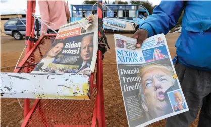  ?? Photograph: Daniel Irungu/ EPA ?? A news vendor in Kiambu, Kenya, offers a newspaper reporting on Joe Biden’s election win earlier this month.