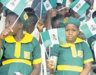  ??  ?? School children wave flags during the 54th anniversar­y in 2014 celebratio­ns of Nigerian independen­ce in Lagos, Nigeria.