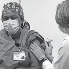  ?? GEORGE WALKER IV/THE TENNESSEAN ?? Tesha S. Akins receives the first COVID-19 vaccine at Vanderbilt University Medical Center in Nashville on Dec. 17.