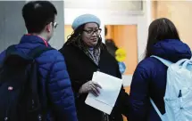  ?? MARSHALL GORBY / STAFF ?? University of Dayton professor Rochonda Nenonene talks with students getting ready to board buses for student-teacher assignment­s at local schools Tuesday.