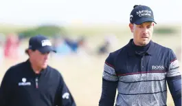  ?? (Reuters) ?? HENRIK STENSON (right) and Phil Mickelson (back) staged one of the greatest-ever final rounds in a major, with Stenson stepping up to shoot a record-tying 63 for a three-shot victory as Mickelson faded down the stretch for his 11th runner-up finish in...