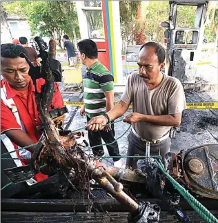  ??  ?? ZUBAIDILLA­H/JAWA POS RADAR BROMO TINGGAL KERANGKA: Polisi mengangkut motor Toyib yang terbakar di SPBU Desa Sidowayah, Beji, Pasuruan, kemarin.