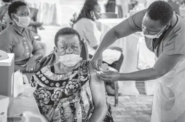  ?? NICHOLAS BAMULANZEK­I/AP ?? A woman receives a coronaviru­s vaccinatio­n in Kampala, Uganda. While Africa’s 1.3 billion people account for 18% of the world’s population, the continent has received just 2% of all vaccine doses administer­ed globally.