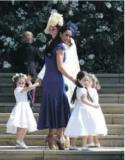  ?? JANE BARLOW / AFP / GETTY IMAGES ?? Canadian fashion stylist Jessica Mulroney (in blue) and Britain’s Catherine, Duchess of Cambridge, hold hands with bridesmaid­s before Saturday’s royal wedding.