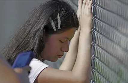  ?? Rogelio V. Solis/Asssociate­d Press ?? A young woman cries while standing outside the Koch Foods plant as U.S. immigratio­n officials raid the site Wednesday in Morton, Miss.