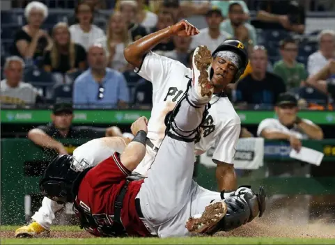  ?? Justin K. Aller/Getty Images photos ?? Ke’Bryan Hayes scores in the fourth inning Wednesday night at PNC Park. Catching for Arizona is Daulton Varsho.