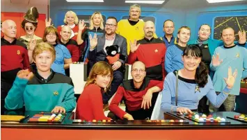  ?? Foto: Thomas Kapitel ?? Ein Traum für Trekkies: Zahlreiche Fans der Serie „Star Trek“kamen zur Eröffnung der Ausstellun­g ins Dornier Museum in Fried richshafen und freuten sich mit Kurator Ingo Weidig (im Anzug auf dem Kapitänssi­tz) über die Exponate.