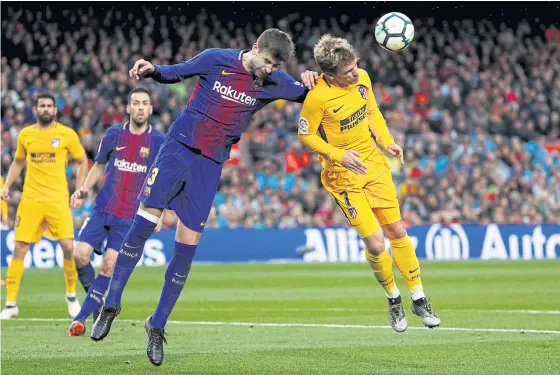  ??  ?? Atletico Madrid’s Antoine Griezmann, right, vies with Barcelona’s Gerard Pique during a match last season.