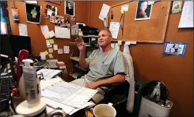  ?? NWA Democrat-Gazette/J.T. WAMPLER ?? T.L. Nelms, owner of the Restaurant on the Corner in Fayettevil­le, sits in his office Wednesday. On the wall hangs a picture of longtime Dickson Street icon Roger Koetter who operated Rogers Rec from 1954-1986.