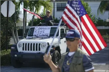  ?? PATRICK SEMANSKY — THE ASSOCIATED PRESS ?? Supporters of President Donald Trump watch his motorcade drive by in West Palm Beach, Fla., on Sunday.