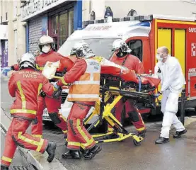  ??  ?? Los bomberos evacuan a un herido en el ataque del viernes.