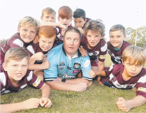  ?? Picture: MIKE BATTERHAM ?? The Burleigh Bears Maroons under-9s Taiyo Palmer, 9, Stone Foster, 9, Ty Wojciechow­ski, 9, Jai Eccles, 9, Coby Allen, 8, Jacob McAllister, 8, Cruz Judge, 9, Chase Harris, 9, and Billy-J Hamilton, 9, have NSW supporter and club coaching director Dean Allen looking over his shoulder before tonight’s Origin I.