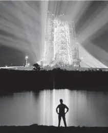  ?? AP ?? Spotlights illuminate the 363-foot-tall Saturn V booster rocket on the launch pad at the Kennedy Space Center, carrying the Apollo 8 spacecraft and its crew of three astronauts on Dec. 19, 1968.