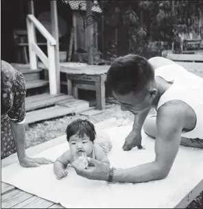  ?? © Paul Faris/Courtesy of Mary Ann Thurmond and Tim Faris ?? A Japanese-American soldier sees his daughter for the first time at the Rowher Relocation Center in July 1945. Paul Faris took this and other photograph­s at Rowher. Sarah Wilkerson Freeman, professor of history at Arkansas State University, said the...