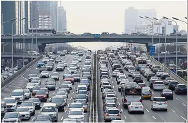  ?? — Reuters ?? Steeper fall: A file picture showing cars on a main road in Beijing’s central business area. Car sales fell a steeper 15.8% from a year earlier to 2.37 million vehicles last month.