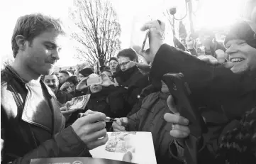  ?? — Reuters photos ?? Rosberg of Germany signs autographs.