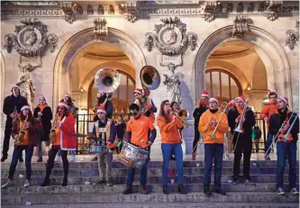  ??  ?? People wearing Santa Claus hats play music outside the Opera House in Paris. — AFP