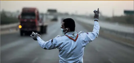  ??  ?? Above: An Egyptian boy scout distribute­s fruit to drivers breaking their Ramadan fast.