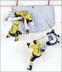  ?? MARK HUMPHREY — THE ASSOCIATED PRESS ?? Winnipeg’s Paul Stastny (25) scores against Nashville goalie Pekka Rinne (35) during the second period in Game 1 Friday in Nashville, Tenn. Predators’ Nick Bonino (13) and P.K. Subban (76) also defend.