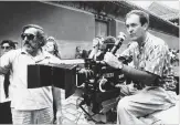  ?? NEAL ULEVICH THE ASSOCIATED PRESS ?? May 2, 1987: Bertolucci, right, checks a scene during the filming of the movie “The Last Emperor,” in the Forbidden City of Beijing, China.