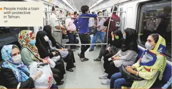  ?? AP ?? People inside a train with protective in Tehran.