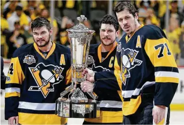  ?? Keith Srakocic / Associated Press ?? Pittsburgh team captain Sidney Crosby, center, displays the Prince of Wales Trophy with Evgeni Malkin, right, and Chris Kunitz after the Penguins beat Ottawa in Game 7 of the Eastern Conference finals onThursday.