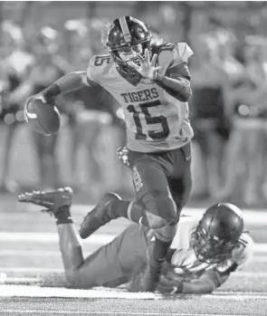  ?? INDEONLINE.COM/KEVIN WHITLOCK ?? Massillon quarterbac­k Jayvian Crable eludes the grasp of a Bishop Sycamore defender on Sept. 4, 2020.