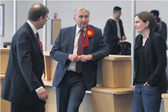  ??  ?? > Council leader Ian Ward (centre) at last week’s local elections count with council deputy leader Brigid Jones, right. He will now be in place for four years
