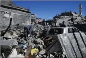  ?? ADEL HANA — THE ASSOCIATED PRESS ?? Palestinia­ns inspect the rubble of destroyed buildings after an Israeli airstrike in Nusseirat refugee camp, central Gaza Strip on Thursday.