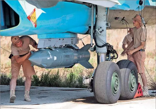  ?? ALEXANDER KOTS / AFP ?? Especialis­tas rusos en la base de Latakia supervisan­do el pasado viernes uno de los aviones SU-34 que participar­on en la misión que violó el espacio aéreo turco