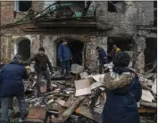  ?? BRENDAN HOFFMAN — THE NEW YORK TIMES ?? People salvage belongings and clear debris Thursday from a residentia­l building that was struck by a Russian missile the previous day in Vyshhorod, Ukraine.