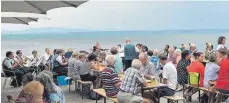  ?? FOTO: HELMUT VOITH ?? Trotz drohender Wolken haben die Fischbache­r das Konzert ihrer Musikkapel­le am See genossen.