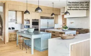  ??  ?? The kitchen gives off a very modern vibe, with light timber cabinetry and marble benchtops.