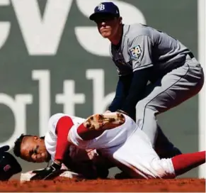  ?? (Photo by Winslow Townson, AP) ?? Boston Red Sox’s Xander Bogaerts, bottom, loses his helmet as he slides into second safely and avoiding the tag of Tampa Bay Rays’ Adeiny Hechavarri­a during the first inning of Saturday’s game.