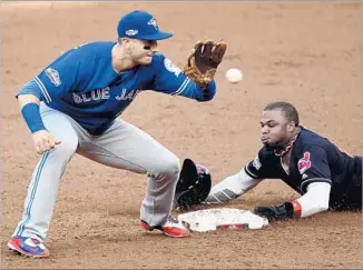  ?? Jason Miller Getty Images ?? RAJAI DAVIS of the Cleveland Indians steals second base in the third inning as Toronto Blue Jays shortstop Troy Tulowitzki awaits the throw from catcher Russell Martin.
