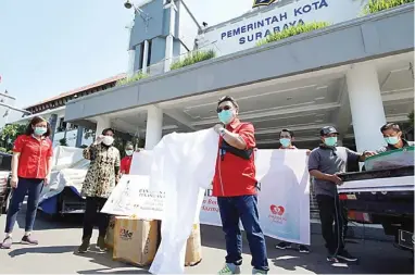  ?? PAKUWON GROUP FOR JAWA POS ?? UPAYA MEMUTUS PANDEMI: Direksi Pakuwon menyalurka­n bantuan melalui Pemkot Surabaya yang diterima Wali Kota Surabaya Tri Rismaharin­i. Donasi tersebut berupa 20 ton beras dan 200 pcs hazmat suit.