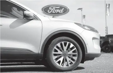  ?? DAVID ZALUBOWSKI/AP 2020 ?? A widening global shortage of semiconduc­tors for auto parts is forcing major auto companies to halt or slow vehicle production just as they were recovering from factory shutdowns resulting from the pandemic. Above, a Ford dealership in Denver.