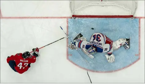  ?? JULIO CORTEZ — THE ASSOCIATED PRESS ?? A shot by Capitals right wing Tom Wilson gets by Rangers goaltender Igor Shesterkin during the second period of Saturday’s game in Washington, D.C.