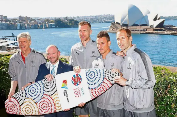  ??  ?? Hello mate: (from left) Arsenal manager Arsene Wenger, New South Wales Minister for Trade and Industry Niall Blair, Arsenal defenders Per Mertesacke­r and Laurent Koscielny and goalkeeper Petr Cech posing for a photograph in front of the Sydney Opera...