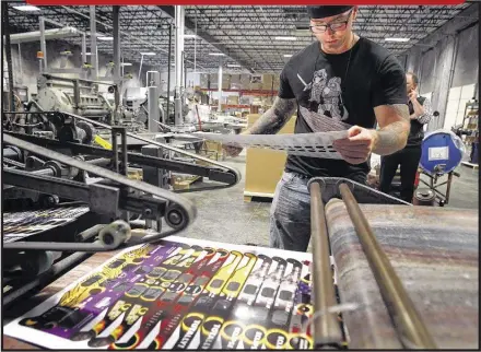  ?? MARK WEBER/THE COMMERCIAL APPEAL ?? American Paper Optics machine operator Kevin Bachman looks over sheets of eclipse glasses the company is making in advance of a total solar eclipse that will cross the United States in August 2017. The company expects nearly 300 million people will need protective eyewear to view the eclipse.