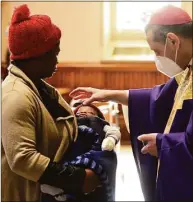  ?? Ned Gerard / Hearst Connecticu­t Media ?? Bishop Frank Caggiano administer­s ashes to 5-month-old Paschal Emejeamara and his mother, Maria, during Ash Wednesday Mass at St. Augustine Cathedral, in Bridgeport on March 2.