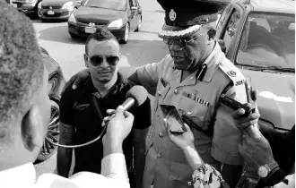  ?? KENYON HEMANS/PHOTOGRAPH­ER ?? Assistant Commission­er of Police Bishop Dr Gary Welsh, head of the Public Safety and Traffic Enforcemen­t Branch, speaking with reporters as driver Dennis Dietrih looks on yesterday.