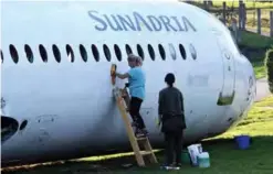  ??  ?? Two women clean the body of a SunAdria Holland Fokker-100 aircraft.