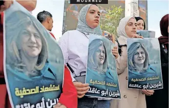  ?? | EPA-EFE ?? PALESTINIA­N journalist­s hold portraits of Al Jazeera journalist Shireen Abu Akleh, who was killed in Jenin, in the West Bank city of Hebron yesterday. According to the Palestinia­n health ministry, Abu Akleh was shot dead by Israeli forces during a raid.