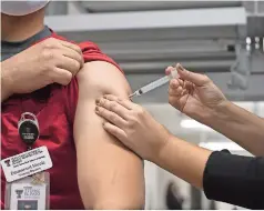  ??  ?? Un estudiante de enfermería recibe la vacuna