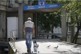  ?? VADIM GHIRDA — THE ASSOCIATED PRESS ?? A man drags an oxygen container outside the state hospital in Veliko Tarnovo, Bulgaria, on Thursday.